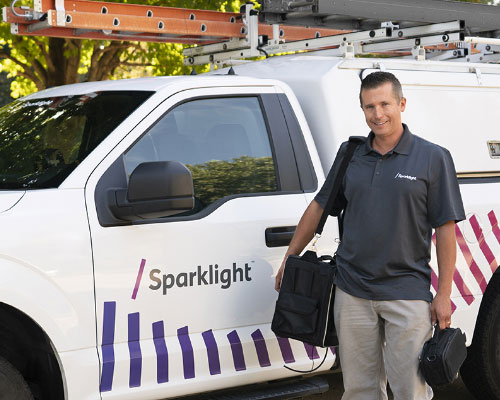 A smiling Sparklight associate by a Sparklight truck