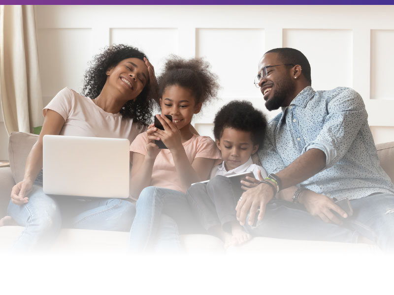 family on couch using wireless devices