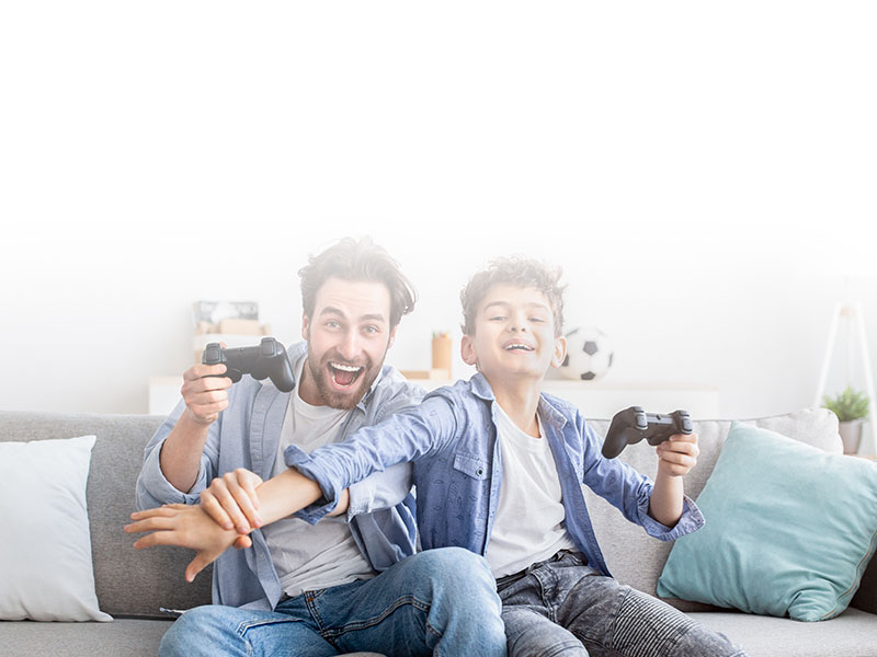 smiling adult and child playing on game console