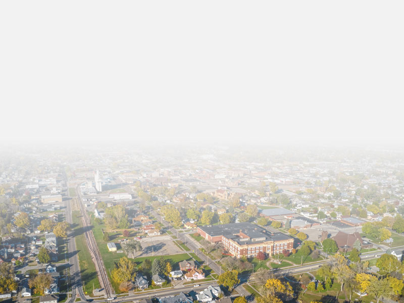 A sky view of Norfolk, NE in autumn that shows grass, trees, streets, houses and buildings