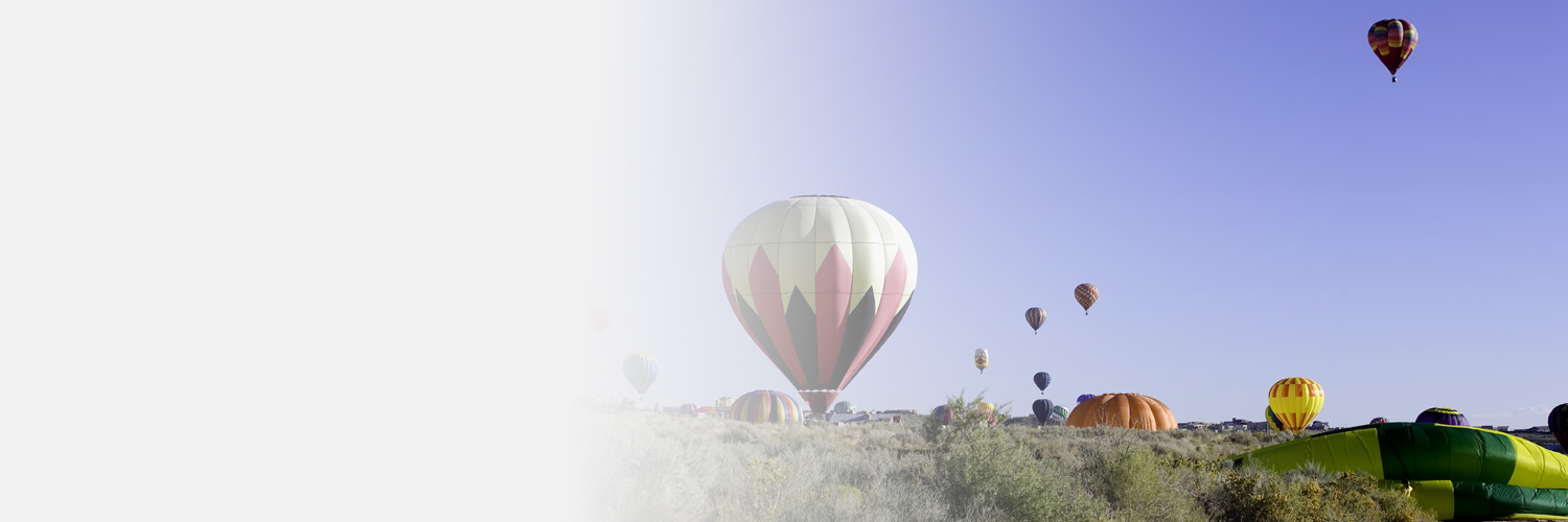 Hot air balloons in the sky and landing in Rio Rancho, NM