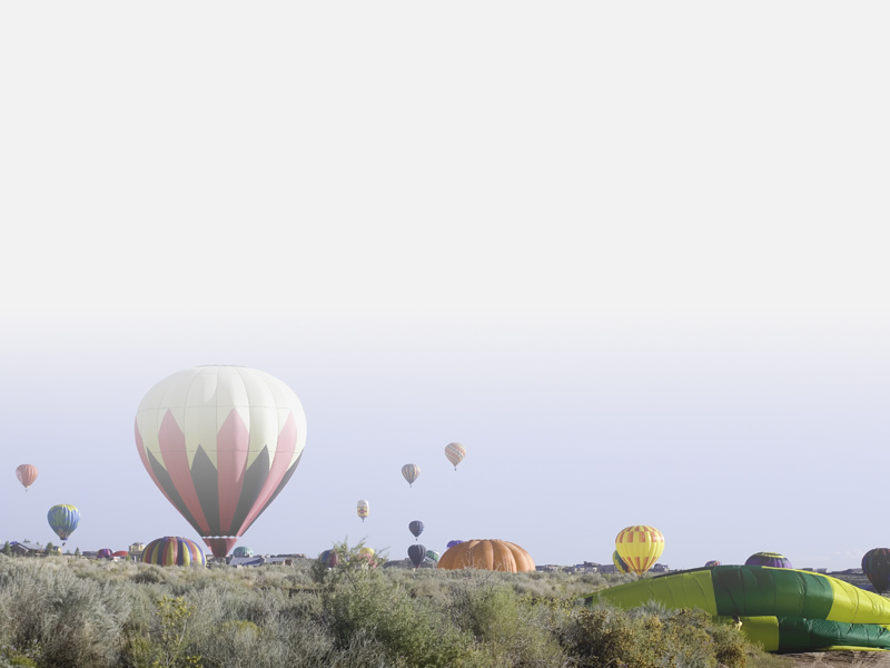 Hot air balloons in the sky and landing in Rio Rancho, NM