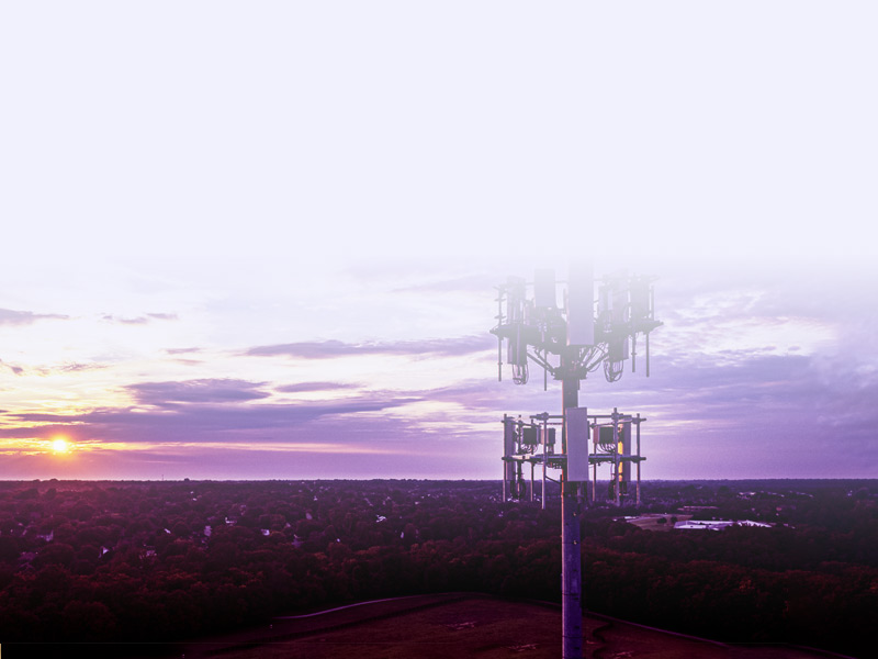 A cellular tower is shown along with a beautiful purple, cloudy sky